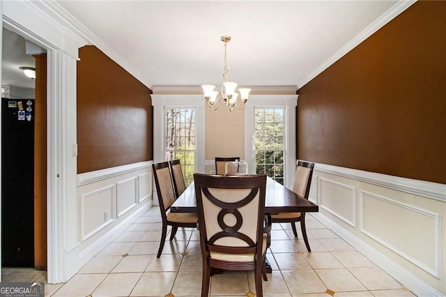 1472 Hartman Dr SW, Lilburn, GA 30047 - dining room featuring a decorative wall, a chandelier, wainscoting, crown molding, and light tile patterned floors
