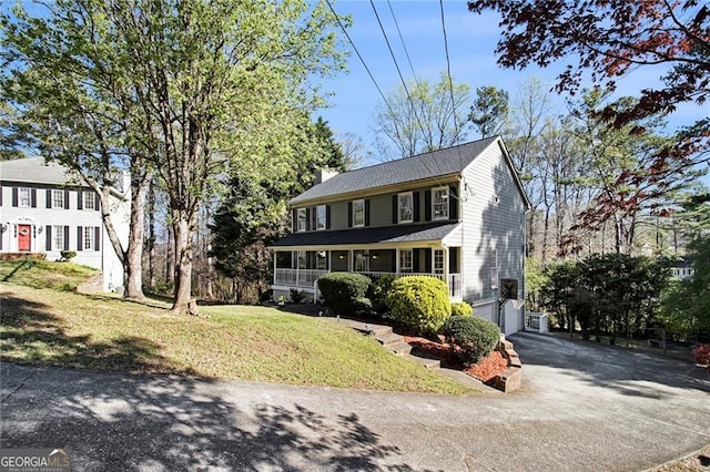 1472 Hartman Dr SW, Lilburn, GA 30047 - colonial inspired home featuring asphalt driveway, a chimney, and a front lawn
