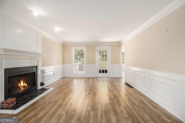 1472 Hartman Dr SW, Lilburn, GA 30047 - unfurnished living room with a tiled fireplace, a decorative wall, a textured ceiling, wood finished floors, and crown molding