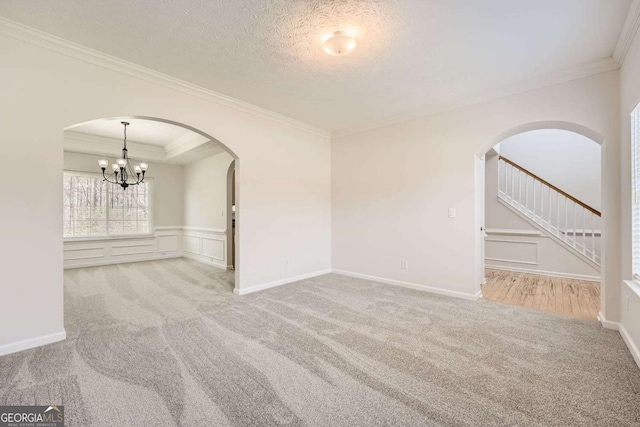 4157 Medlock Woods Dr, Snellville, GA 30039 - unfurnished room with an inviting chandelier, a decorative wall, carpet floors, and arched walkways