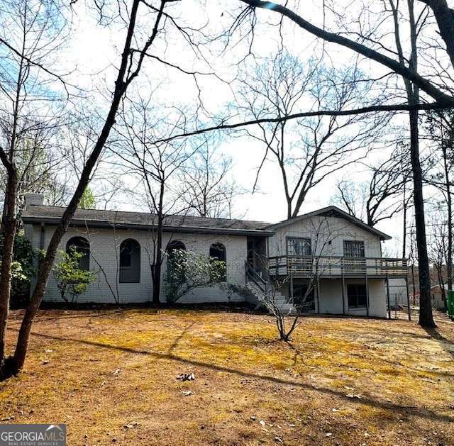 rear view of property with a deck and stairs
