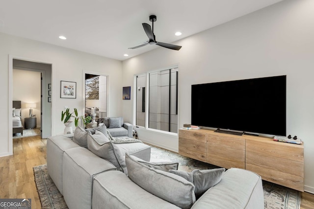 living area with a ceiling fan, recessed lighting, baseboards, and wood finished floors