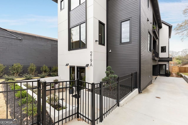 doorway to property with stucco siding and fence