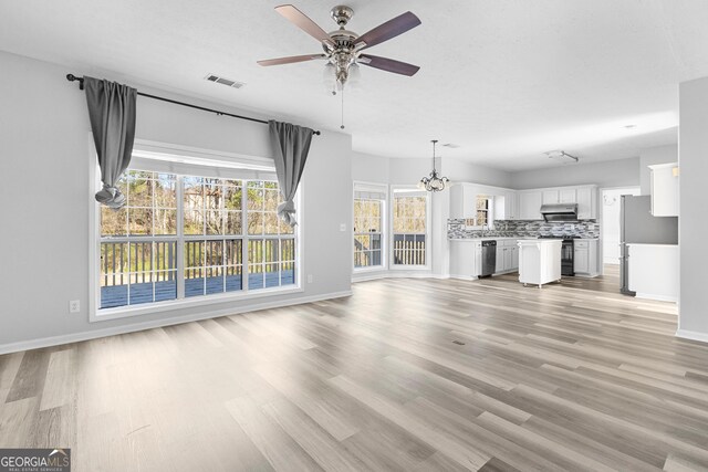 1484 Highland Bluff Ct, Suwanee, GA 30024 - unfurnished living room featuring light wood-type flooring, ceiling fan with notable chandelier, baseboards, and visible vents