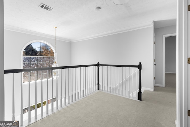 1484 Highland Bluff Ct, Suwanee, GA 30024 - hallway featuring carpet flooring, an upstairs landing, a textured ceiling, visible vents, and ornamental molding
