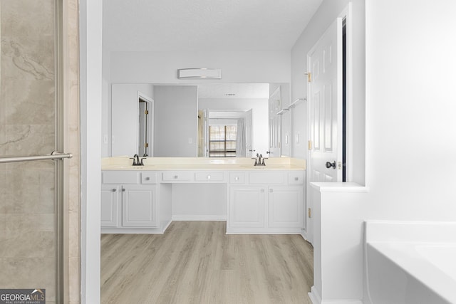 1484 Highland Bluff Ct, Suwanee, GA 30024 - full bathroom featuring a bath, double vanity, wood finished floors, and a stall shower