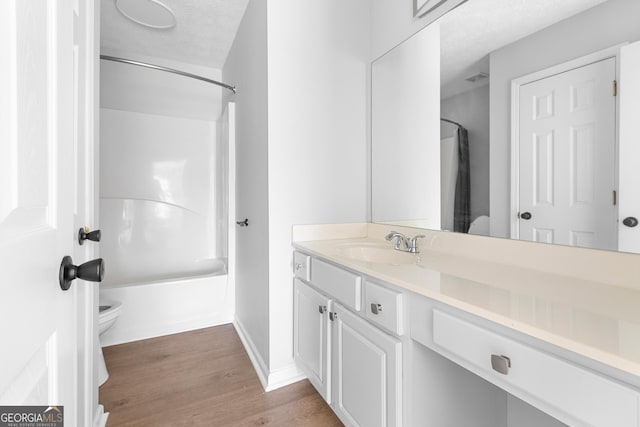 1484 Highland Bluff Ct, Suwanee, GA 30024 - bathroom featuring shower / bathing tub combination, vanity, toilet, a textured ceiling, and wood finished floors