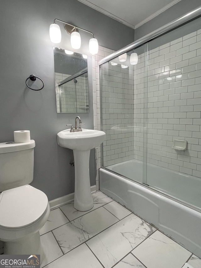 1105 Claxton Dairy Rd, Dublin, GA 31021 - bathroom featuring crown molding, marble look tiles, shower / bath combination with glass door, toilet, and baseboards