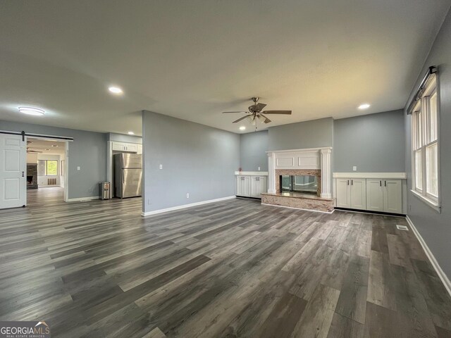 1105 Claxton Dairy Rd, Dublin, GA 31021 - unfurnished living room featuring a barn door, ceiling fan, recessed lighting, baseboards, and dark wood-style flooring