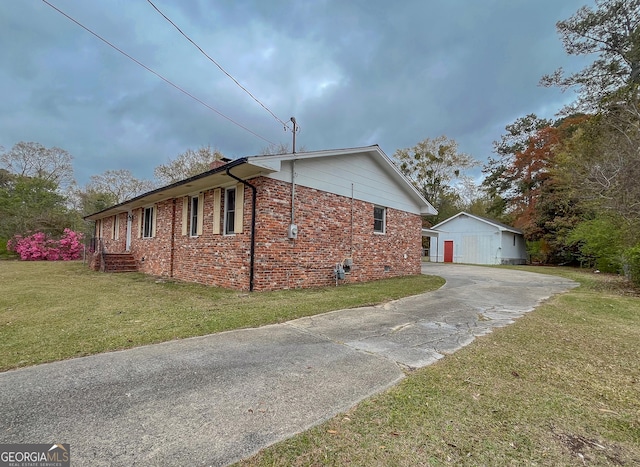 1105 Claxton Dairy Rd, Dublin, GA 31021 - view of side of home with brick siding, a lawn, driveway, an outdoor structure, and crawl space