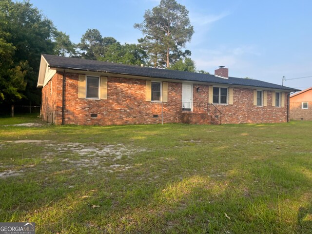 1105 Claxton Dairy Rd, Dublin, GA 31021 - view of front of house with crawl space, brick siding, a front lawn, and a chimney