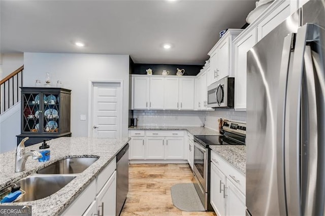 197 Saddleridge Dr, Bremen, GA 30110 - kitchen featuring appliances with stainless steel finishes, white cabinetry, recessed lighting, light wood-style flooring, and tasteful backsplash