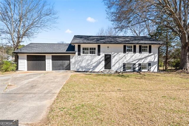 view of front of property featuring driveway, a garage, and a front yard