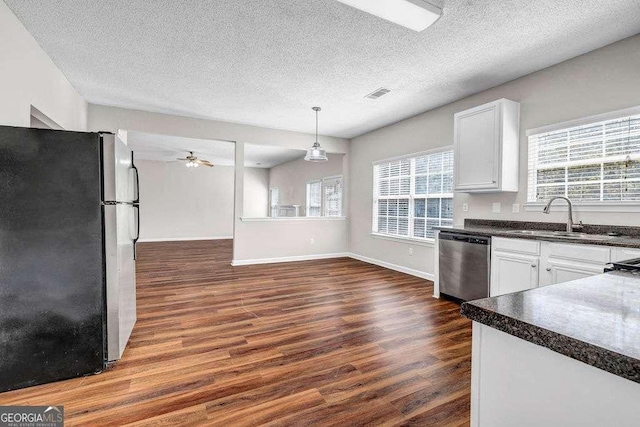 4970 Wewatta St SW, Atlanta, GA 30331 - kitchen featuring appliances with stainless steel finishes, dark countertops, dark wood-style floors, healthy amount of natural light, and a textured ceiling
