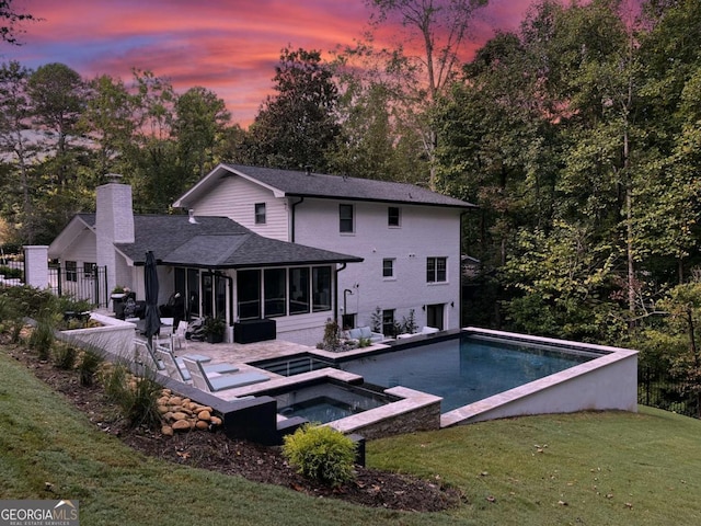 2672 Langland Ct NE, Atlanta, GA 30345 - rear view of property with a chimney, a sunroom, a patio area, a pool with connected hot tub, and roof with shingles