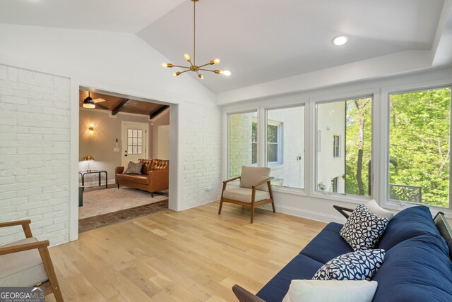 living area with lofted ceiling, a healthy amount of sunlight, and light wood finished floors