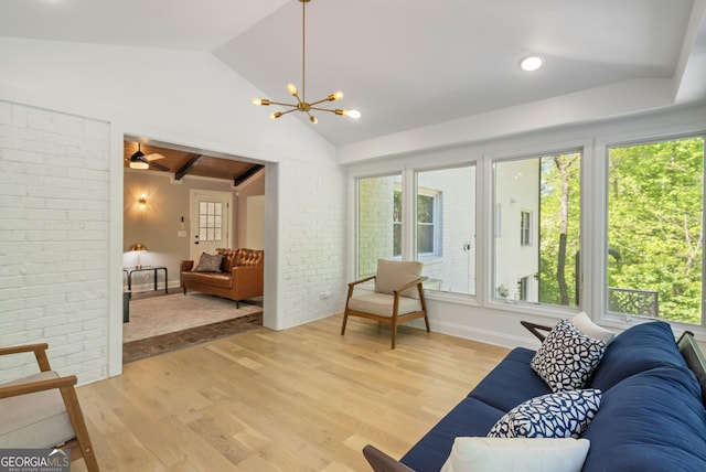 2672 Langland Ct NE, Atlanta, GA 30345 - living room with vaulted ceiling, plenty of natural light, light wood-type flooring, brick wall, and a chandelier