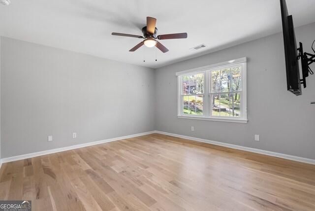 empty room featuring ceiling fan, baseboards, light wood-style floors, and visible vents