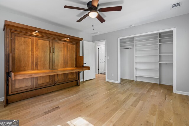 unfurnished bedroom featuring baseboards, a ceiling fan, visible vents, and light wood-style floors