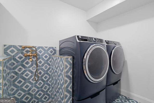 washroom featuring separate washer and dryer, baseboards, and laundry area