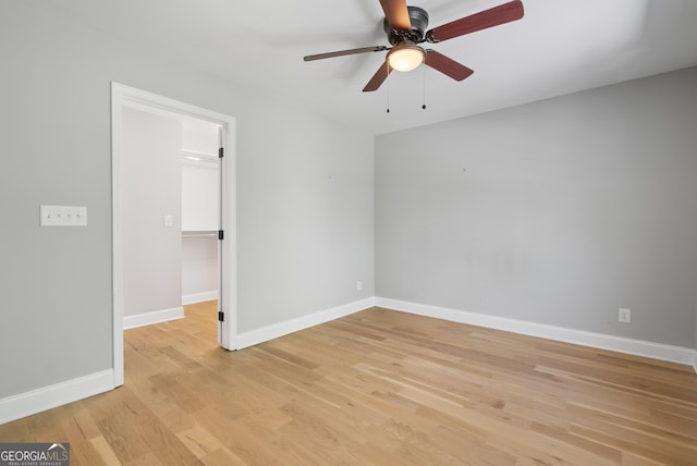 unfurnished room featuring ceiling fan, baseboards, and light wood-style floors