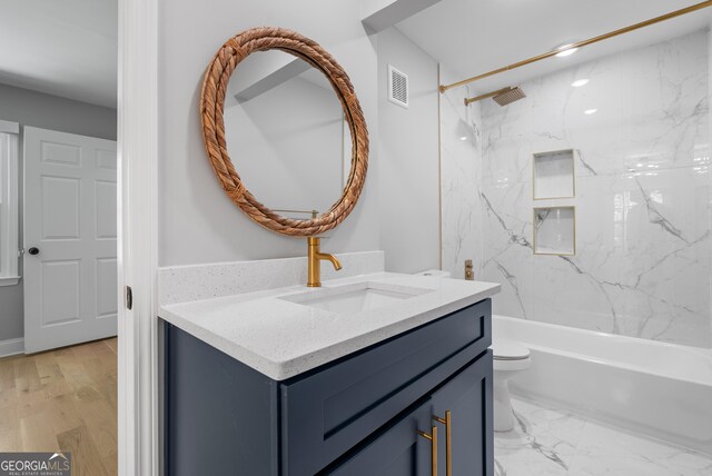 bathroom with visible vents, toilet, vanity, and bathtub / shower combination