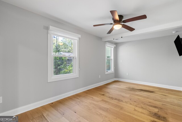 spare room featuring a ceiling fan, baseboards, and light wood-style floors
