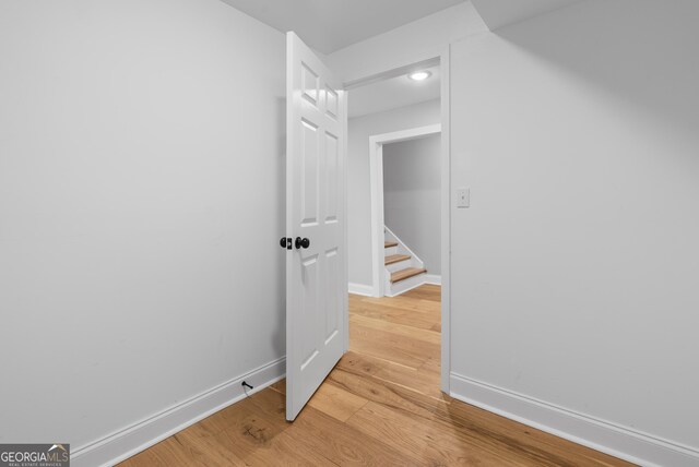 hall with baseboards and light wood-style floors