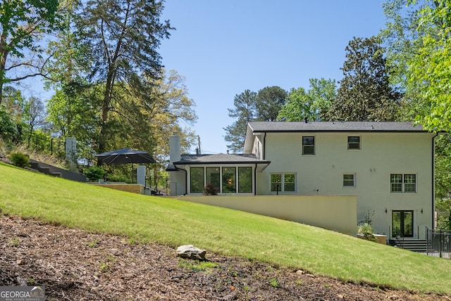 rear view of house featuring a yard