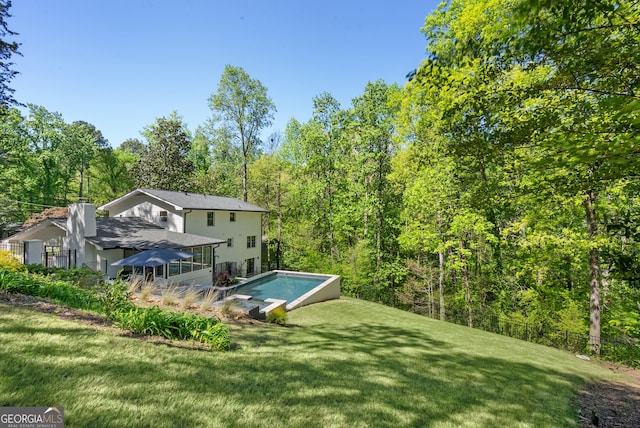 2672 Langland Ct NE, Atlanta, GA 30345 - back of property featuring an outdoor pool, a yard, and a forest view