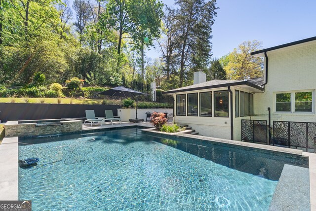 view of swimming pool featuring a fenced in pool, a sunroom, a patio, and an in ground hot tub