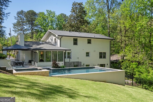 rear view of house with a fenced in pool, a chimney, fence, a yard, and a sunroom