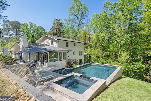 2672 Langland Ct NE, Atlanta, GA 30345 - back of property featuring a sunroom, a yard, a chimney, a pool with connected hot tub, and a patio area