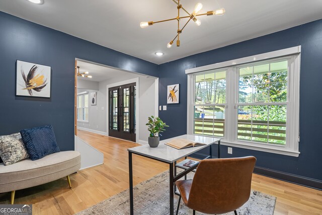 office area with a wealth of natural light, wood finished floors, and a chandelier
