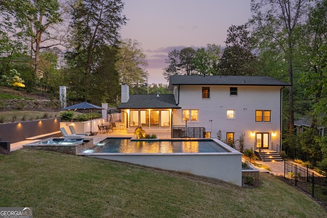 2672 Langland Ct NE, Atlanta, GA 30345 - back of property at dusk with an in-ground hot tub, a chimney, and a patio area