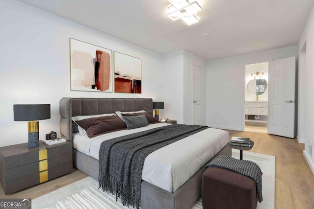 bedroom featuring connected bathroom and wood finished floors