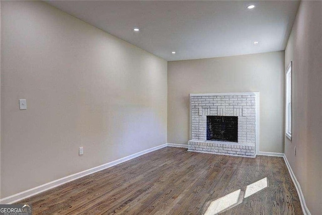 810 Commodore Dr NW, Atlanta, GA 30318 - unfurnished living room with wood finished floors, baseboards, a brick fireplace, and recessed lighting