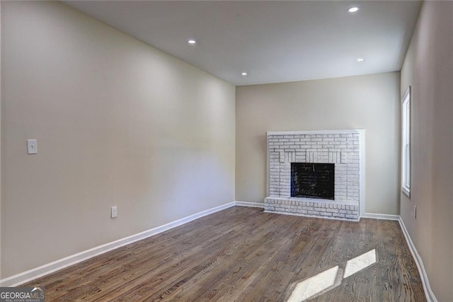 810 Commodore Dr NW, Atlanta, GA 30318 - unfurnished living room with wood finished floors, baseboards, a brick fireplace, and recessed lighting