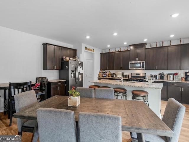 dining room with light wood-style flooring and recessed lighting