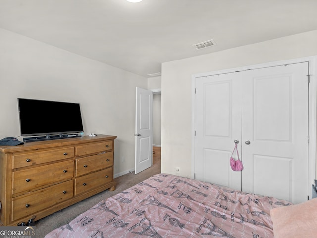 bedroom with baseboards, a closet, light colored carpet, and visible vents