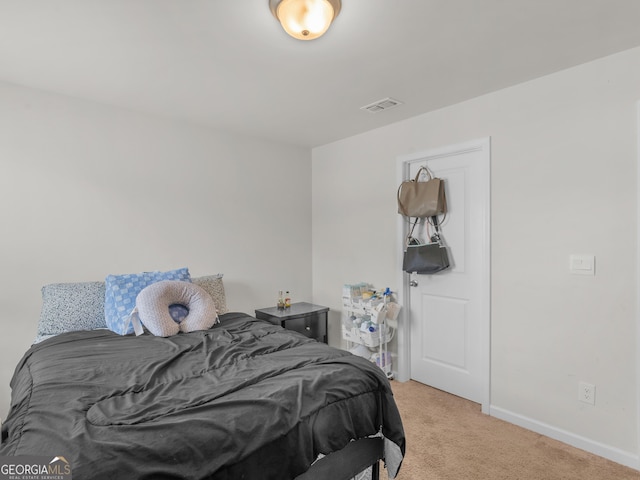 bedroom with baseboards, visible vents, and light colored carpet