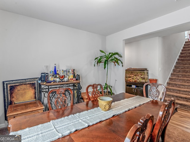 dining space featuring stairway and wood finished floors