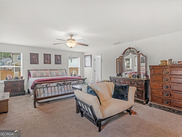 carpeted bedroom featuring ceiling fan and visible vents