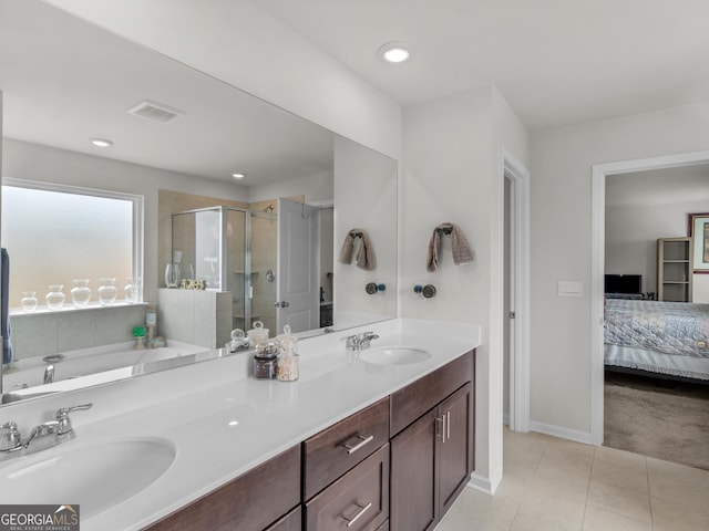 ensuite bathroom with connected bathroom, a sink, tile patterned flooring, and a shower stall