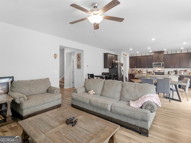 living area featuring a ceiling fan, light wood-style floors, stairway, and recessed lighting