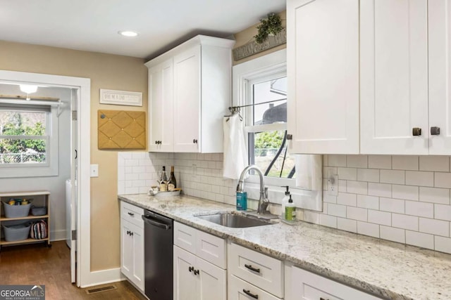 kitchen featuring white cabinetry, dishwashing machine, visible vents, and a sink