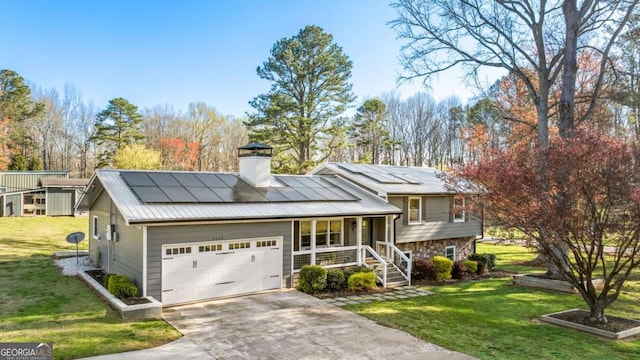 split level home with metal roof, concrete driveway, a front yard, solar panels, and a porch
