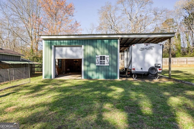 view of pole building featuring a yard, driveway, and fence