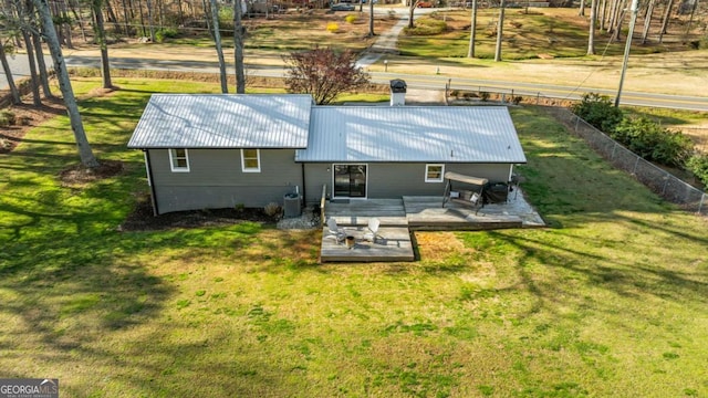 exterior space featuring metal roof, cooling unit, a deck, and a yard