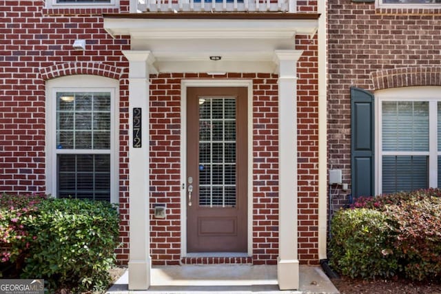 doorway to property with brick siding